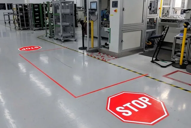Promítané červené linie a symbol STOP u výrobního stroje